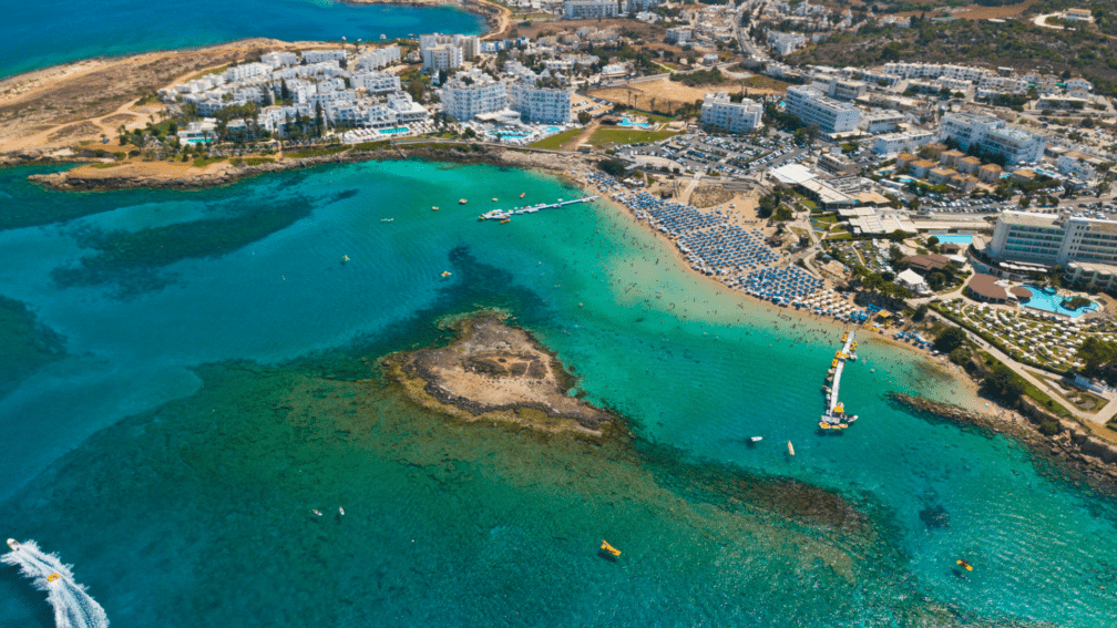 A birds eye view of the island. There are lots of apartment blocks, and it surrounds the sea.