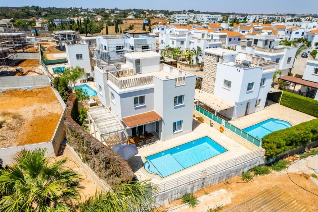 a high angle view of lots of villas, with pools in the gardens