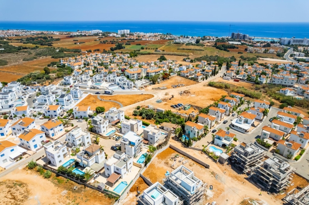 A high angle of lots of villas, the sea is in the background